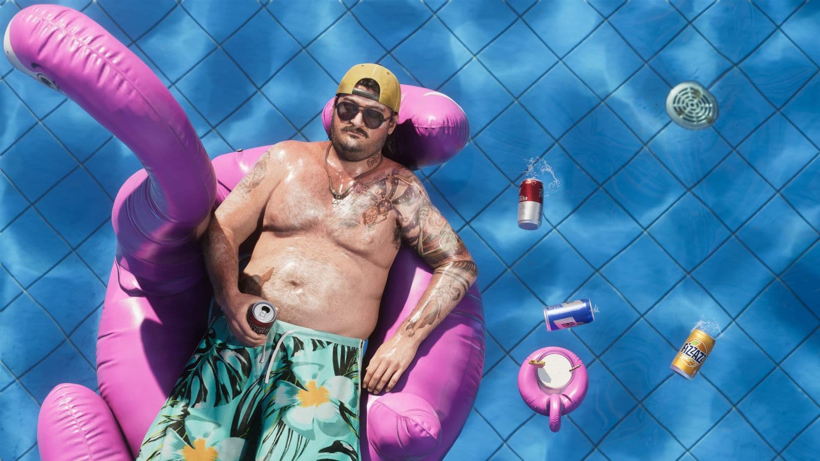 Cal Hampton floating in a pool on an inflatable flamingo, surrounded by beer cans